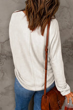 Woman in casual light beige sweater and blue jeans with brown crossbody bag, back view