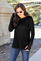 Woman outdoors wearing black long sleeve top and blue jeans, casual fall fashion