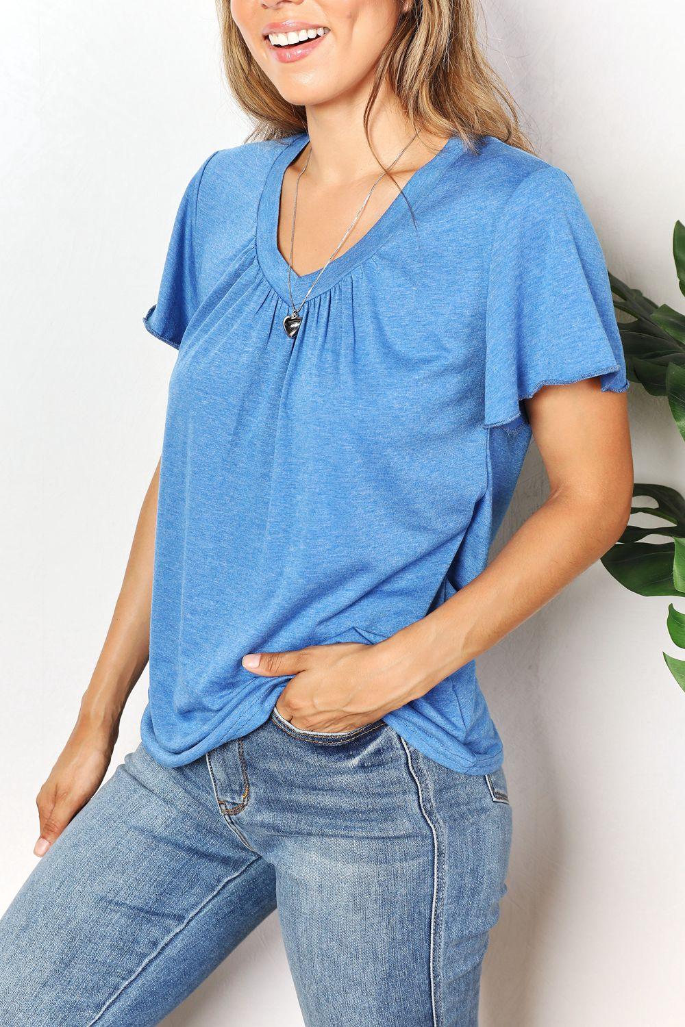 Woman wearing casual blue short sleeve v-neck top and blue jeans
