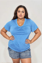 Woman modeling a blue V-neck short sleeve top and denim shorts, casual plus size outfit