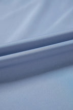 Close-up of smooth light blue fabric with soft folds, ideal for stylish clothing or accessories