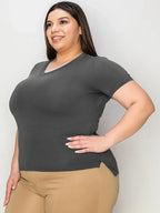 Smiling woman modeling a dark gray V-neck short sleeve t-shirt and beige pants