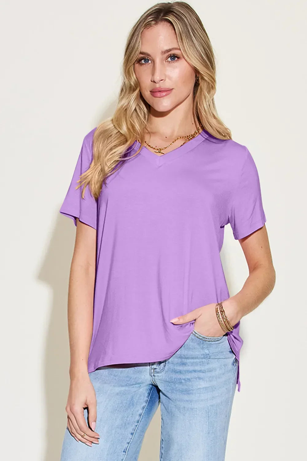Woman wearing a lavender V-neck short sleeve t-shirt with light blue jeans
