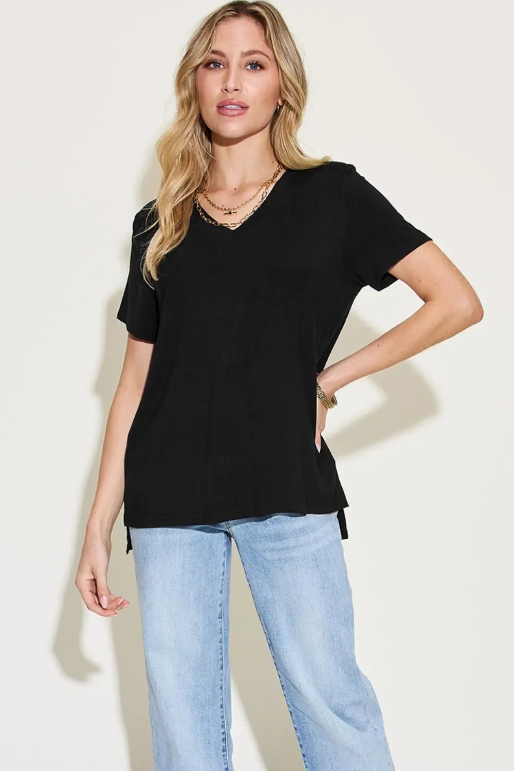 Woman wearing casual black V-neck T-shirt and light blue jeans
