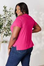Woman in casual hot pink T-shirt and blue jeans, smiling, indoor fashion photo