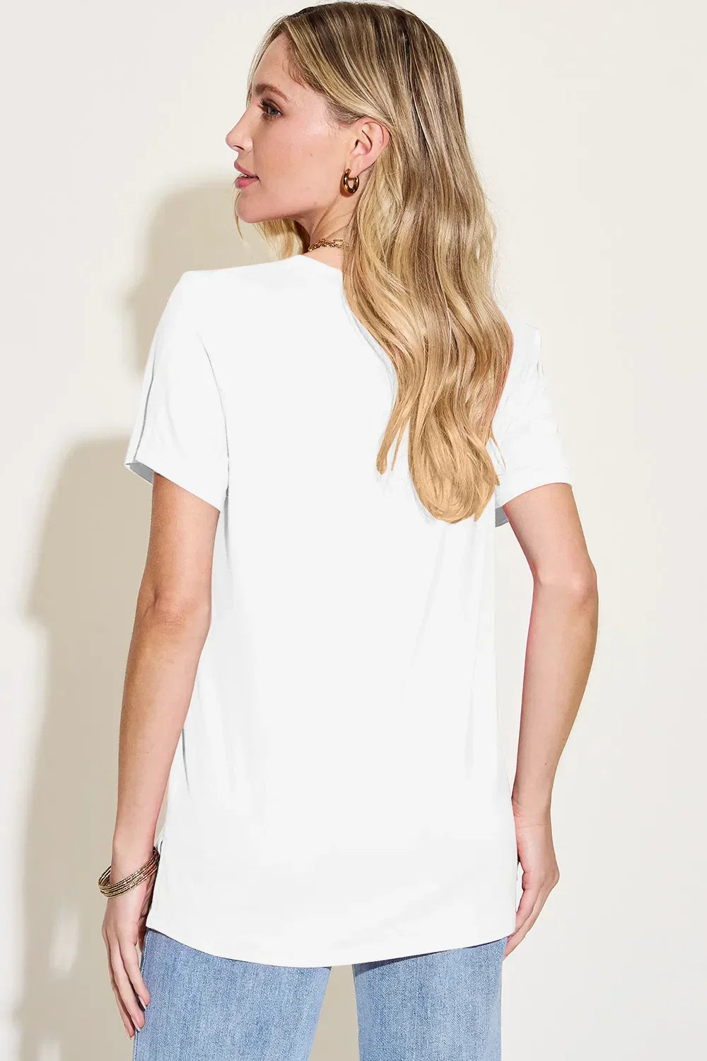 Woman wearing a plain white short sleeve t-shirt and light blue jeans, back view