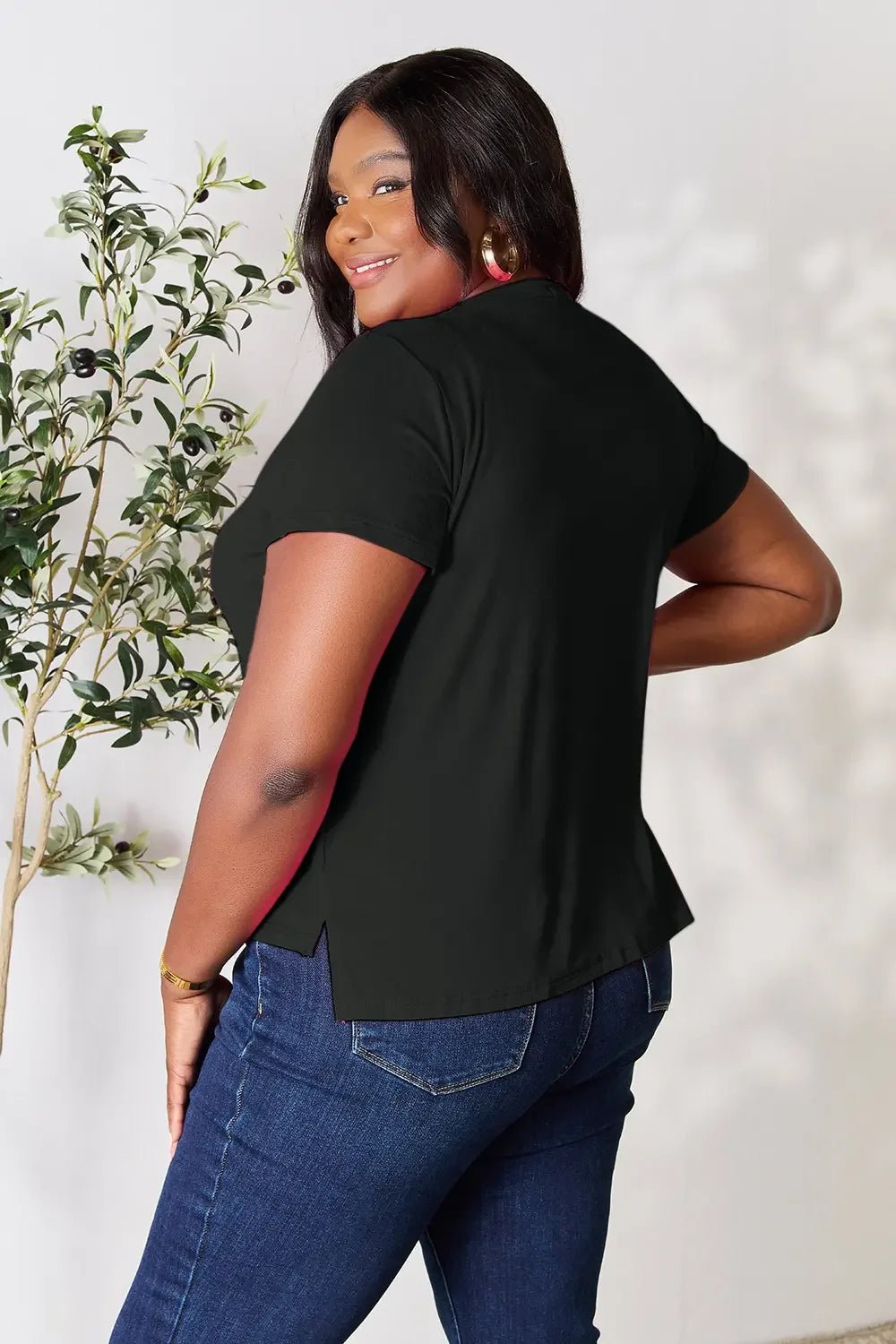Woman in black short sleeve top and blue jeans, plus size casual outfit