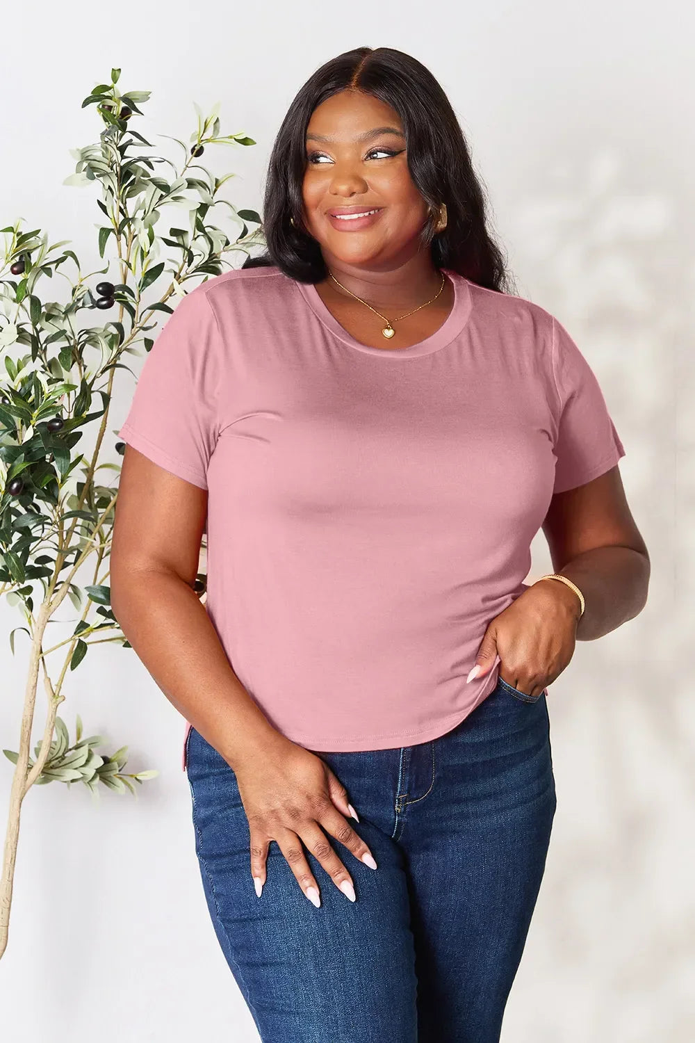 Woman wearing mauve pink short sleeve t-shirt and blue jeans, casual fashion style