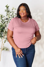 Woman wearing mauve pink short sleeve t-shirt and blue jeans, casual fashion style