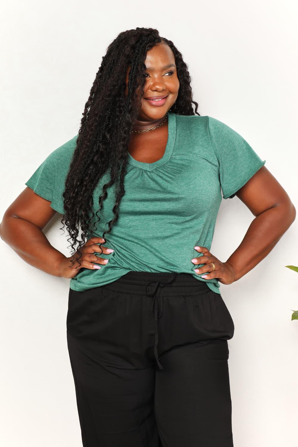 Woman modeling casual green v-neck short sleeve top and black drawstring pants