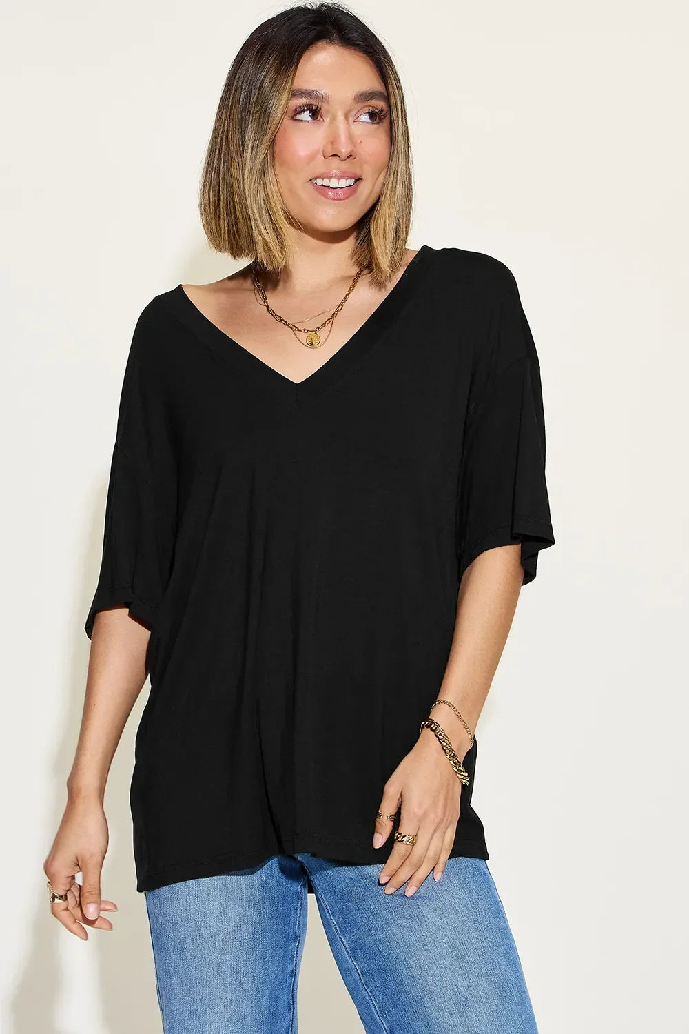 Woman wearing a loose black V-neck T-shirt and blue jeans, casual outfit fashion
