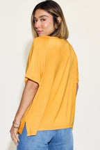 Woman in casual yellow short sleeve top and blue jeans, back view, cream background