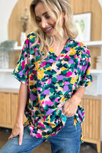 Woman wearing colorful floral print V-neck blouse and blue jeans, casual fashion style