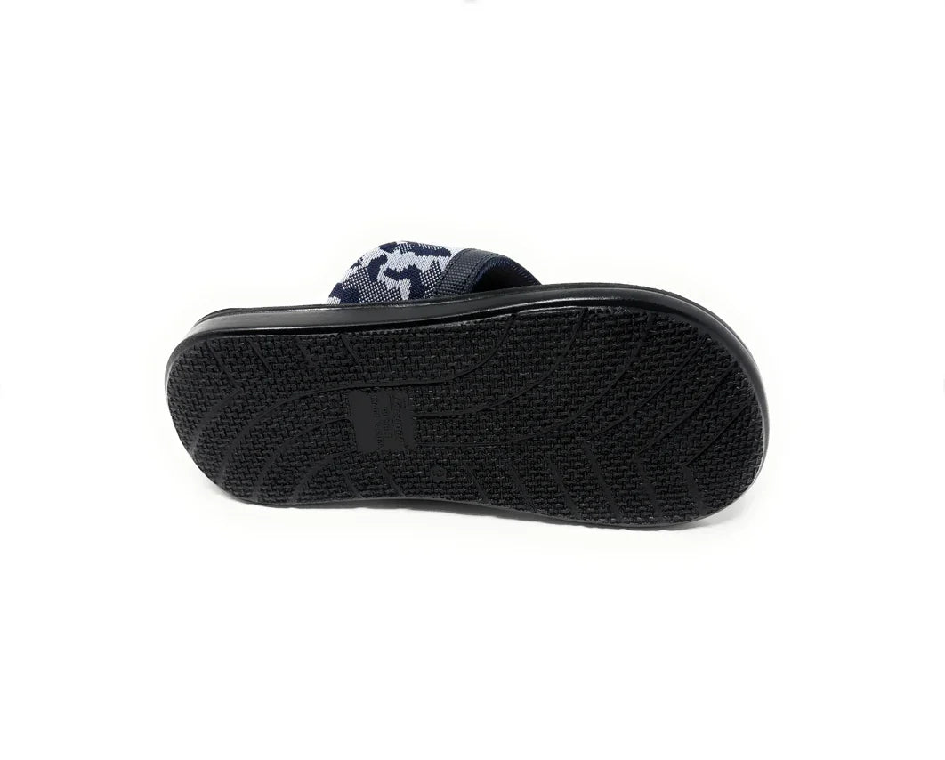 Black rubber sole of a navy camo slide sandal, non-slip tread pattern, casual footwear
