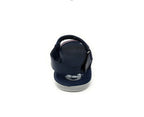 Navy blue children’s sandal with ankle strap, viewed from the back on white background