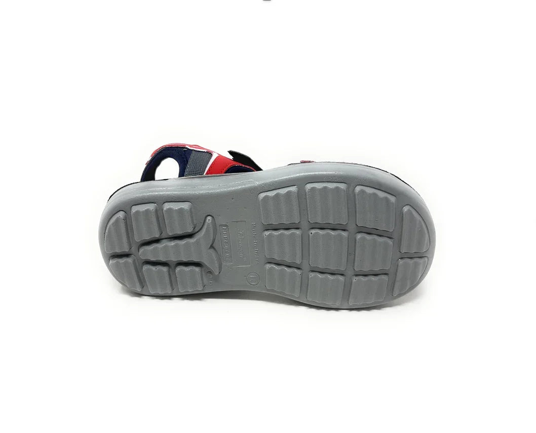 Gray rubber sole of a kid's sandal with red and navy blue upper straps, non-slip tread