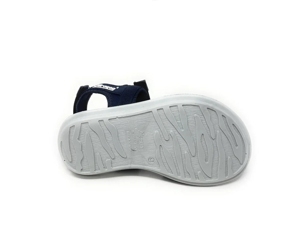 Sandal with textured white rubber sole and navy blue fabric straps, shown from bottom view