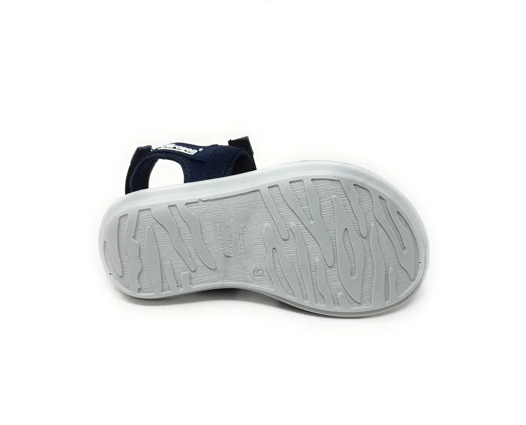 Sandal with textured white rubber sole and navy blue fabric straps, shown from bottom view