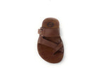 Brown leather sandal with crisscross straps and buckle on white background