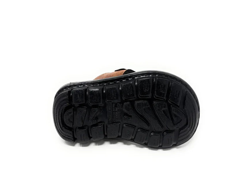Black rubber sole of a shoe with deep tread pattern, photographed on white background