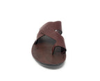 Brown leather slip-on sandal with crisscross straps and open toe on white background