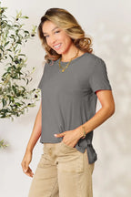 Woman in gray short sleeve t-shirt and beige pants, smiling, casual outfit style