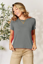 Woman wearing casual grey short sleeve t-shirt with layered gold necklaces