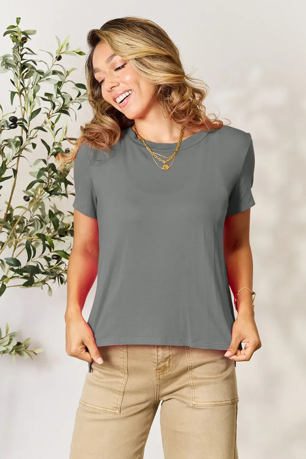 Woman wearing casual grey short sleeve t-shirt with layered gold necklaces