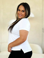 Smiling woman in a white short sleeve t-shirt and black pants, side view, casual style