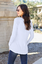Woman in casual white long sleeve top and jeans outdoors, wearing sunglasses