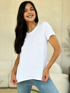 Woman wearing plain white short sleeve t-shirt and blue jeans, standing indoors