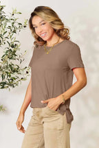 Smiling woman wearing a taupe short sleeve t-shirt and beige pants, casual outfit style