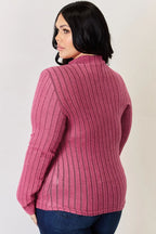 Woman in a pink ribbed long sleeve top and dark jeans, back view